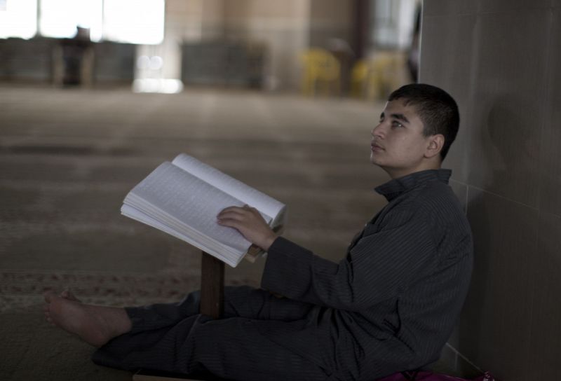 Vak kisfiú Koránt olvas. Forrás: AFP